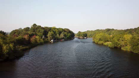 aerial drone video of the river trent in nottinghamshire. the drone flys backwards to reveal and river boat sailing along the water.