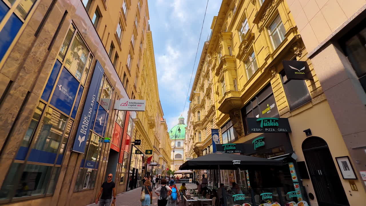 Vienna, Austria - June 9, 2025: Tourists in Vienna's streets. Tourists enjoy a lively Vienna street, surrounded by beautiful architecture and cafes
