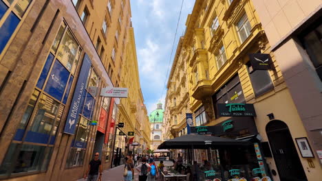 vienna, austria - june 9, 2025: tourists in vienna's streets. tourists enjoy a lively vienna street, surrounded by beautiful architecture and cafes