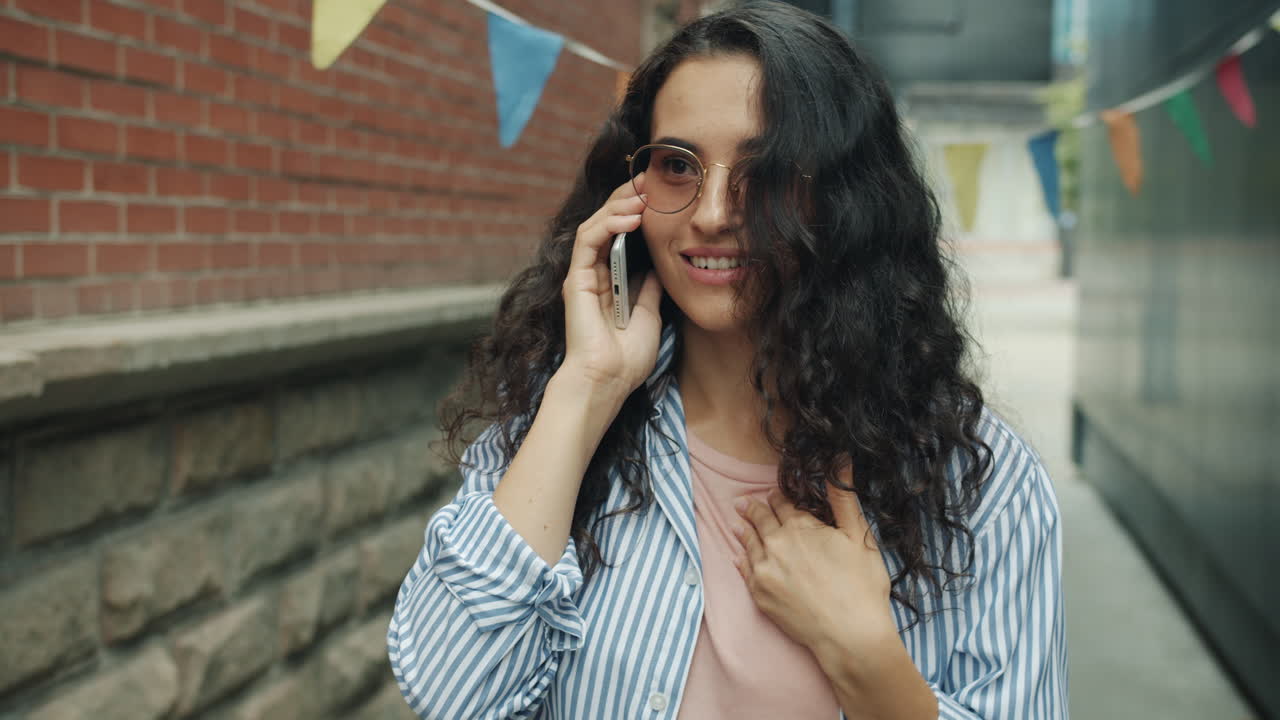 una mujer hablando por teléfono afuera.