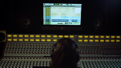 unrecognizable sound engineer touching soundboard in recording music