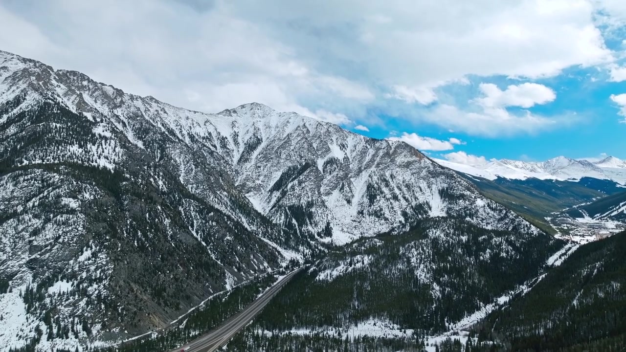 Valle di montagna Frisco Gulch con fitta foresta sempreverde e cime innevate, panoramica aerea con drone