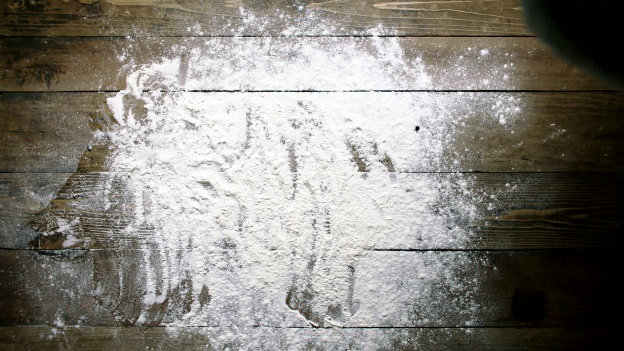 mujer lanza la masa a la superficie de la mesa con harina en cámara lenta