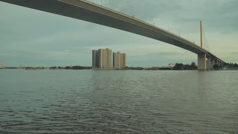 looking at the building across the river in a public park