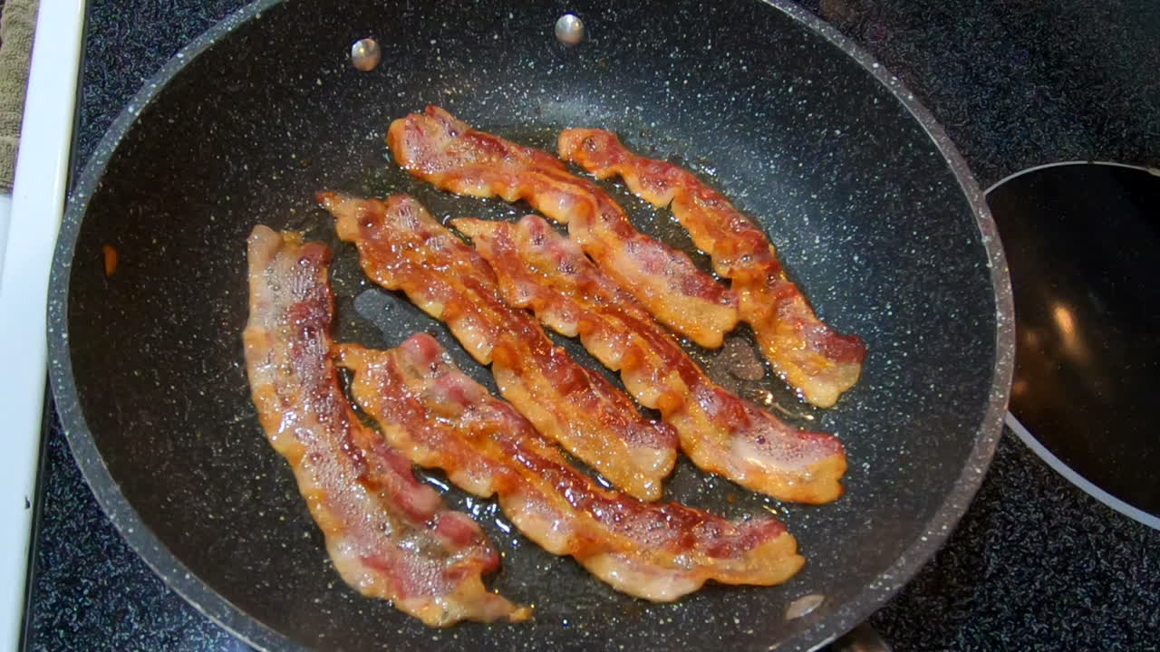 Frying bacon on stove top in home