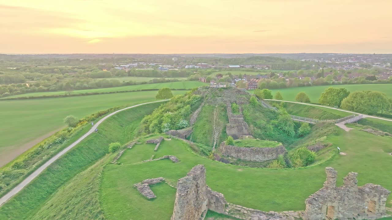 Drone descends in soft evening light on historic ruins and landscape ridges, Sandal Castle Wakefield UK