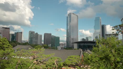 서울 시내 스카이라인, 아셈타워 건물 외관, wtc 서울 트레이드 타워, 코엑스 컨벤션, 전경에 푸른 나무가 있는 봉은사 타일 건물 지붕