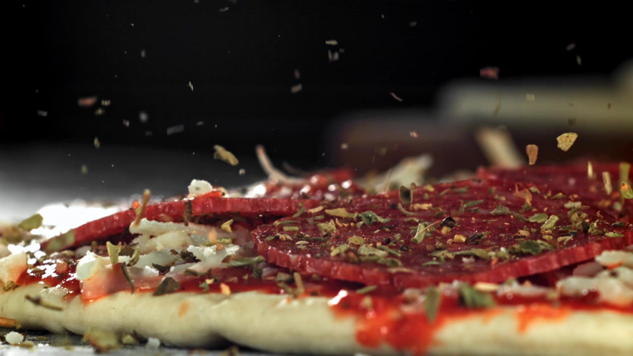 Gerakan Lambat Rempah-rempah Ditaburkan di Atas Pizza Pepperoni Mentah