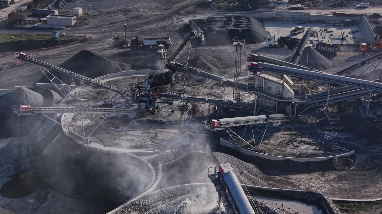 Heavy machinery and conveyor belts at a busy quarry site