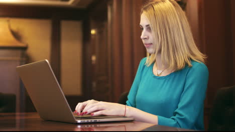 beautiful woman using laptop and typing text on keyboard in home office