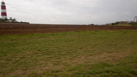 360 panning wide shot of coastal erosion at happisburgh showing the lighthouse in march 2024