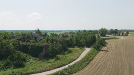 abandoned villa surrounded by lush greenery and farmland in the italian countryside
