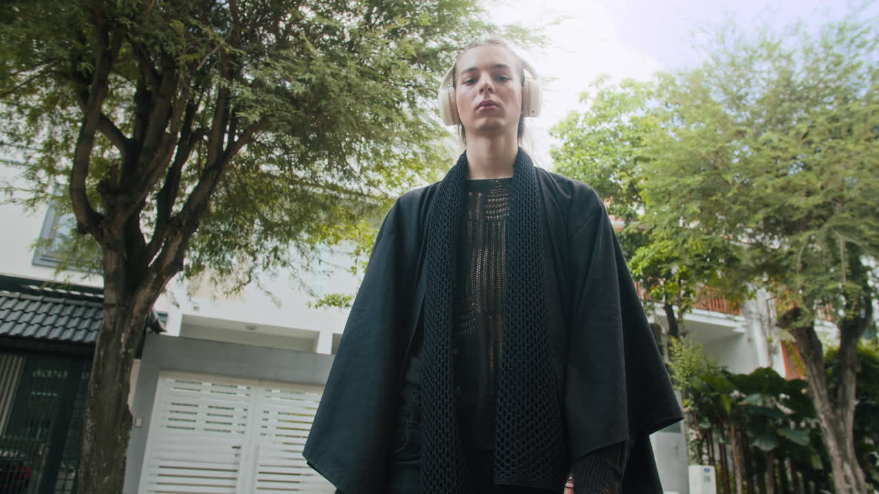 Serious Male Model in Headphones Outdoors Low Angle