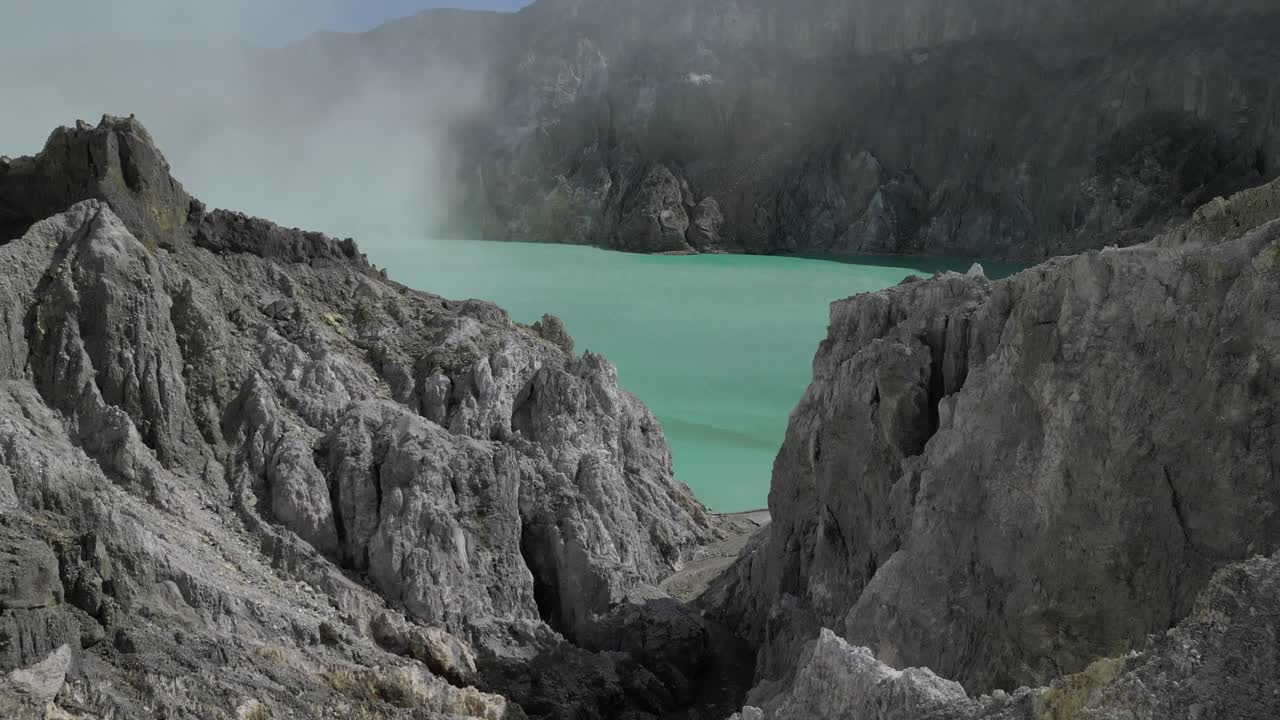 дрон летит в кратер вулкана, захватывая кислое озеро