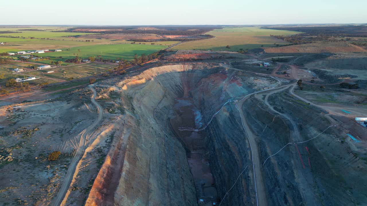 Large open-pit gold mine for mineral extraction in industrial and agricultural area