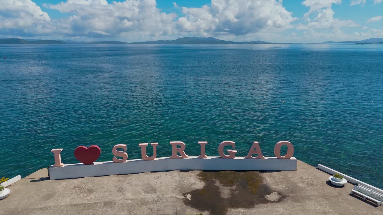 punto de interés aéreo de un i corazón escultura de surigao en el borde del puerto de la ciudad con vistas al océano y los barcos amarrados
