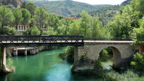 car driving over the old bridges of lago de bolarque spain