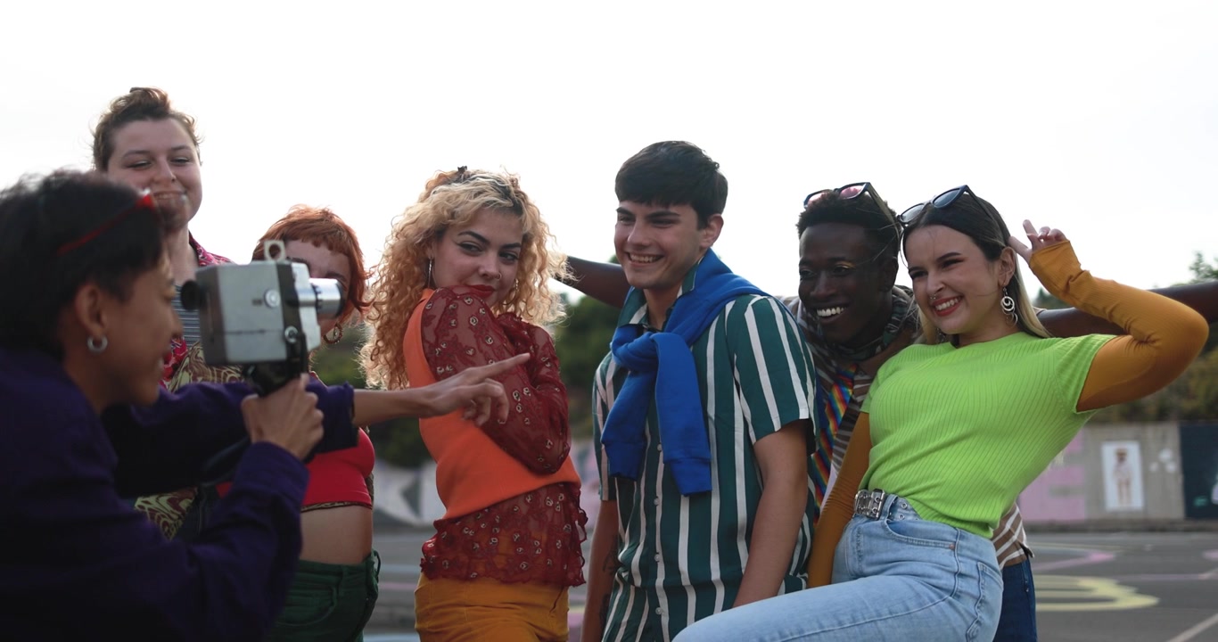 Grupo Diverso de Jovens Amigos Filmando com uma Câmera Retrô