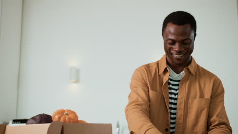 man unpacking vegetables