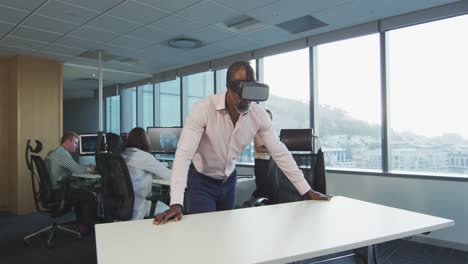 African-American-businessman-wearing-VR-headset-in-modern-office