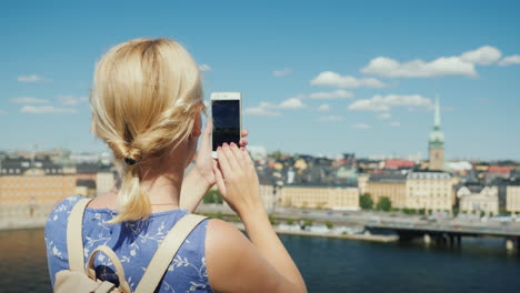 una mujer está fotografiando una hermosa vista de la ciudad de estocolmo en suecia vista trasera turismo en sc