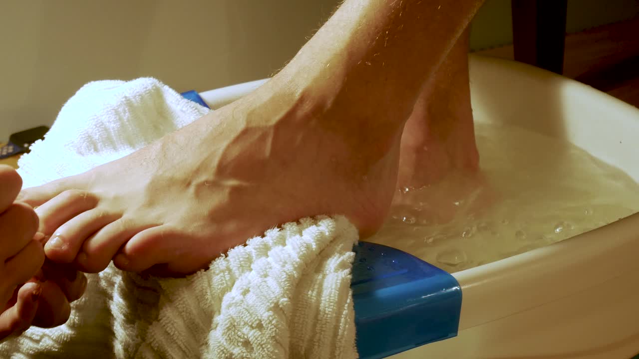 Primo piano del grande piede di un uomo mentre riceve una pedicure.