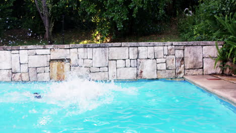 niño con traje de baño rojo sumergiéndose en una piscina