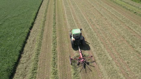 en un campo agrícola en el suroeste de wisconsin, un agricultor rastrilla el heno con un rastrillo giratorio para heno-6