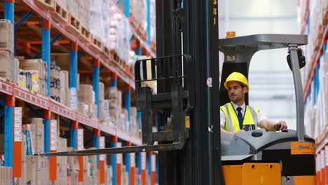 male warehouse worker using forklift truck