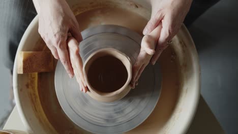 grandmother teaches her granddaughter working on a pottery rotating wheel