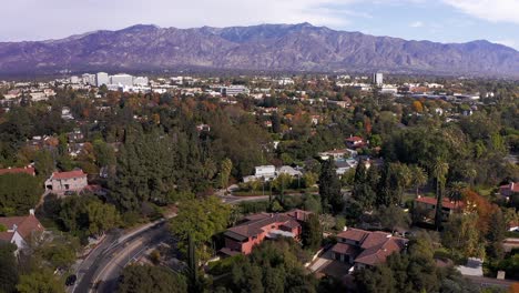 low aerial panning shot of pasadena with mountains in the background