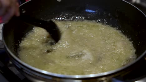 spoon stirring simmering onions in pan, evoking the essence of cooking mastery and meticulous food preparation