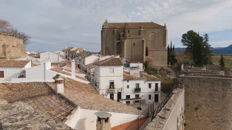 ronda picturesque cityscape with church of the holy spirit and fortified walls, spain