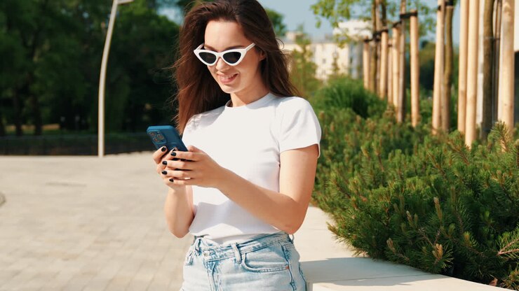 Donna che usa il telefono in un parco