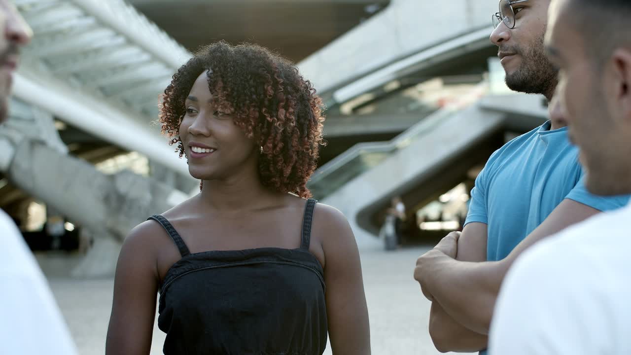 amigos sonrientes de pie en la calle y hablando