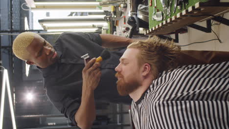 barber dusting loose hair from face of client