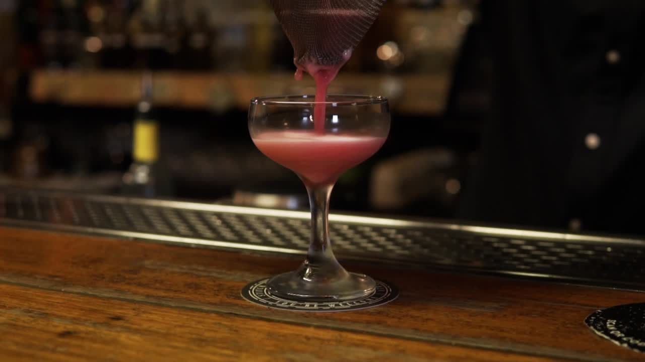 Bartender Slowly Pouring A Cocktail Drink In A Glass At Bar Counter In Sydney, Australia. Slow Motion Shot