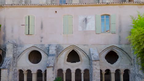 slow establishing shot of a geometric archway in a french abbeys courtyard