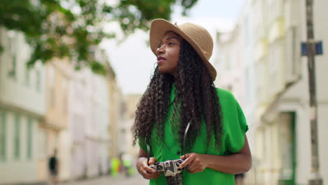 female tourist with camera on vacation in oxford uk exploring city walking along holywell street taking photos 1