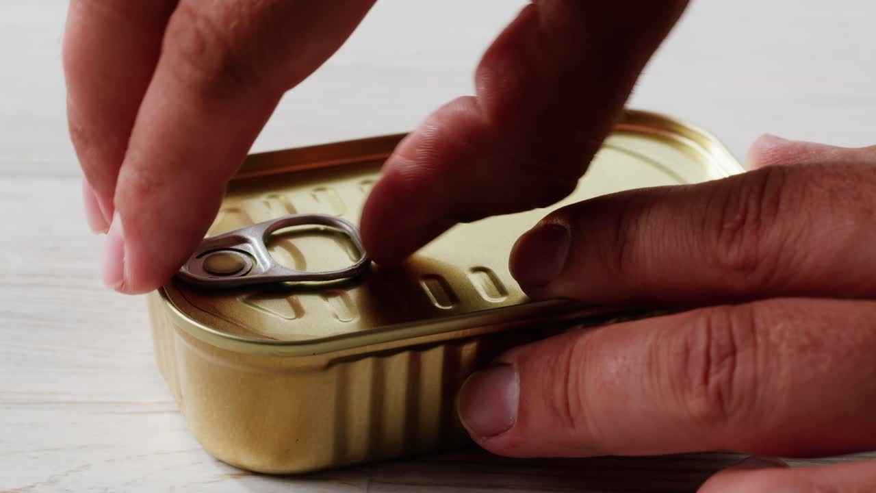 Smoked cod liver in oil in open tin can with fresh greens on wooden table. Seafoods delicacy. High quality 4k footage