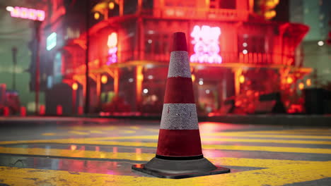 a traffic cone on a wet street in a city at night