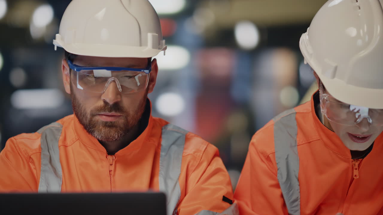 ingenieros profesionales serios hablando juntos con cascos de protección de cerca.