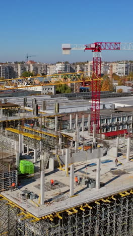 new construction site in the city. creation of modern residential buildings. several cranes operate at the site. aerial view construction site. vertical video