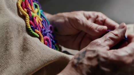close up of hands working with colorful yarn