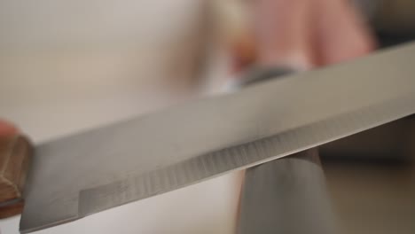 sharpening knife on round seam, slow motion towards camera, copy space