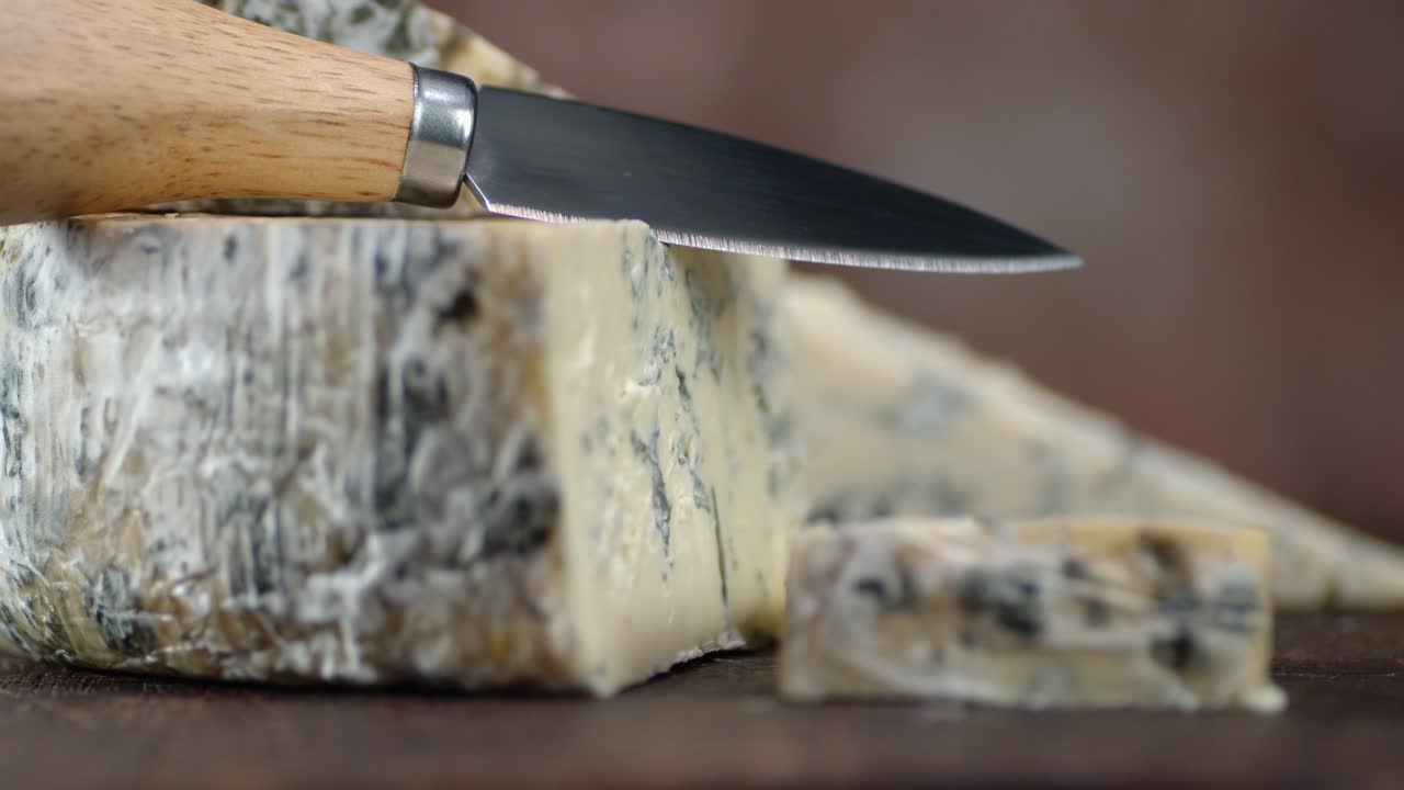 테이블 위에 있는 브리 치즈 조각들이 천천히 회전하고 있습니다.