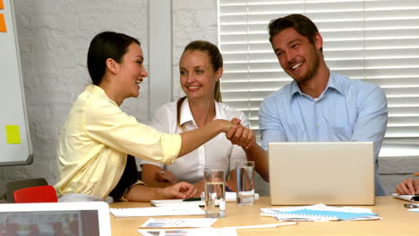 casual business partners shaking hands during meeting