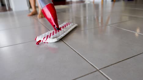 cleaning a tile floor with a spray mop
