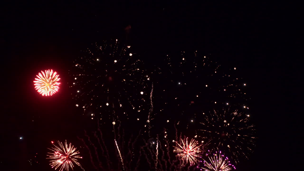 A huge fireworks display filling the darkness with light and smoke