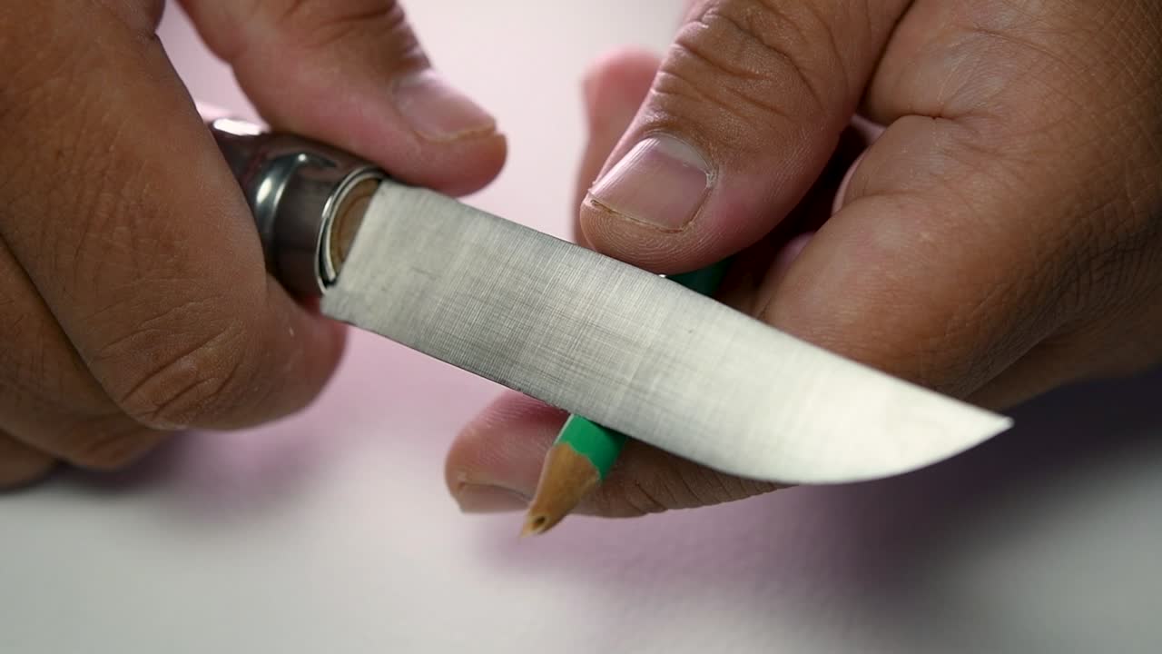 imágenes de manos afilando lentamente un lápiz y algunos lápices de colores con un cuchillo afilado